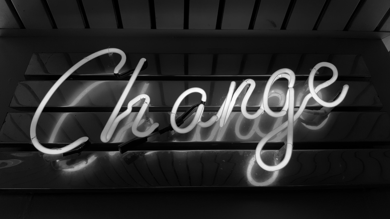 A neon sign saying, "Change" in cursive lettering.